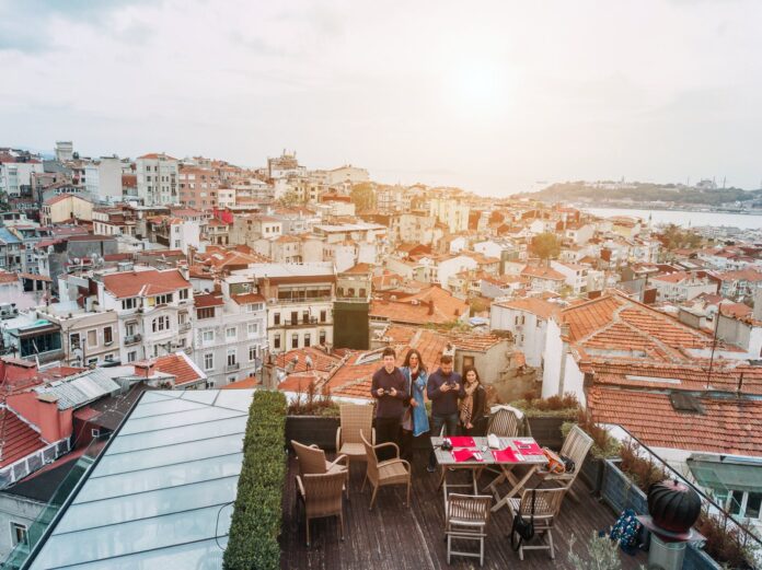 best-hotels-istanbul-rooftop-view Friends enjoying a panoramic Istanbul view from a rooftop terrace