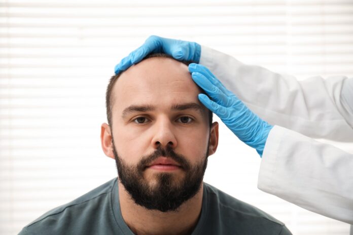 Doctor examining a patient's scalp at a hair transplant clinic in Istanbul