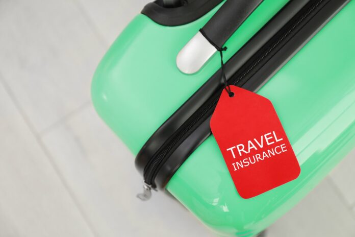 Suitcase with a travel insurance label, viewed from above