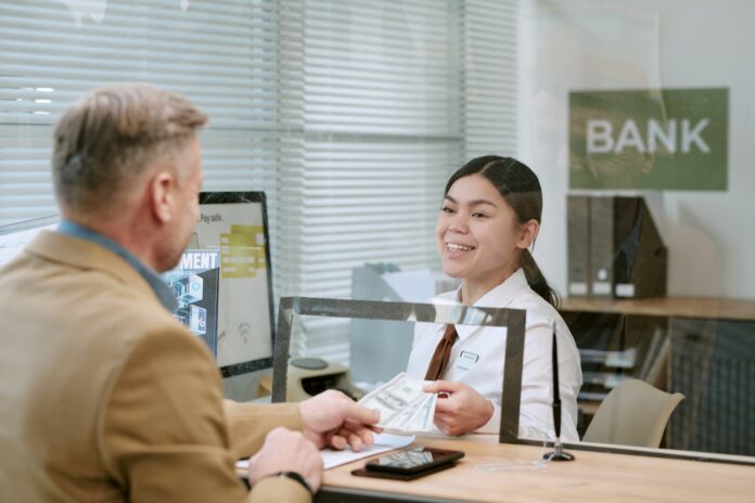 opening-bank-account-istanbul-foreigner Bank teller assisting a customer at a bank counter to open an account