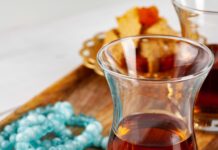 Turkish Drinks Guide: From Çay to Şalgam and Everything in Between Turkish tea served in a traditional tulip-shaped glass with Turkish delight