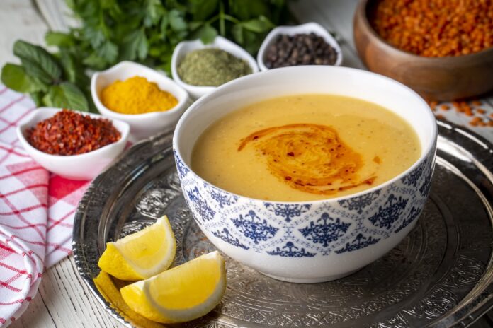 Bowl of traditional Turkish soup with herbs and lemon