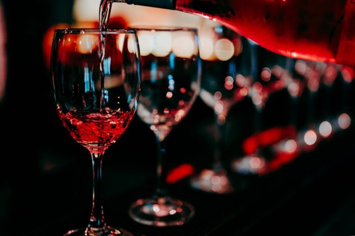Wine glasses being poured at a stylish wine bar