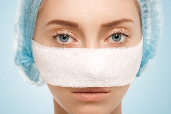 Patient with post-rhinoplasty nose support and bandages